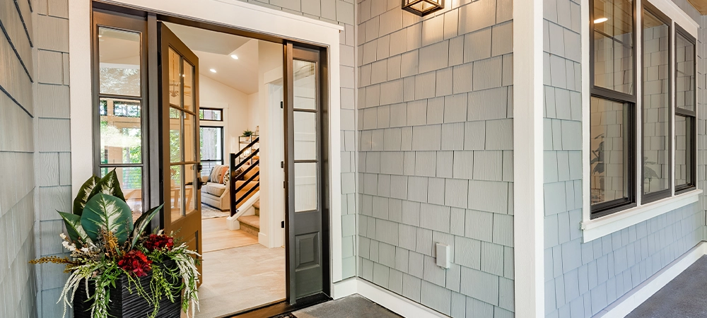 Front entry door of a modern home showing interior staircase and porch