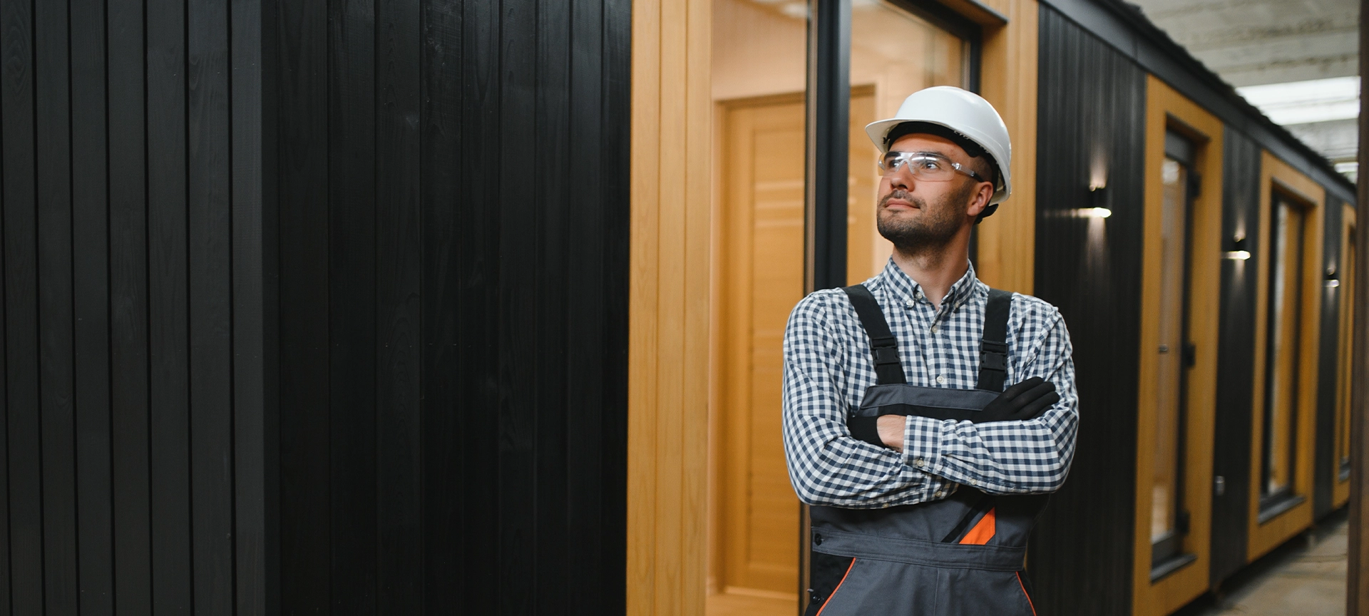 Worker carpenter assembling a modular house.